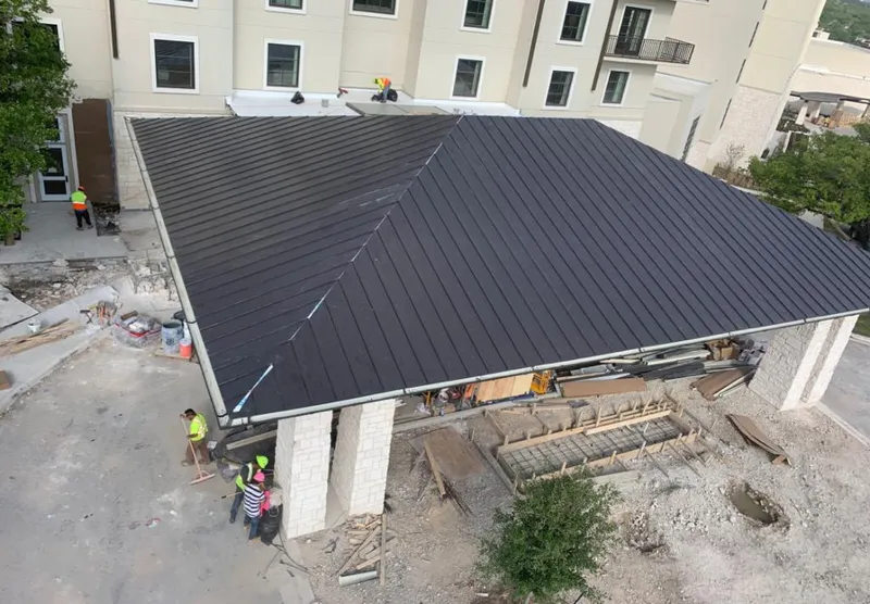 Metal roofing installation team working on a commercial building in Somers